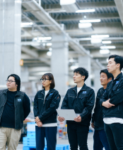 広い倉庫で研修を受ける5人のSGLスタッフ。