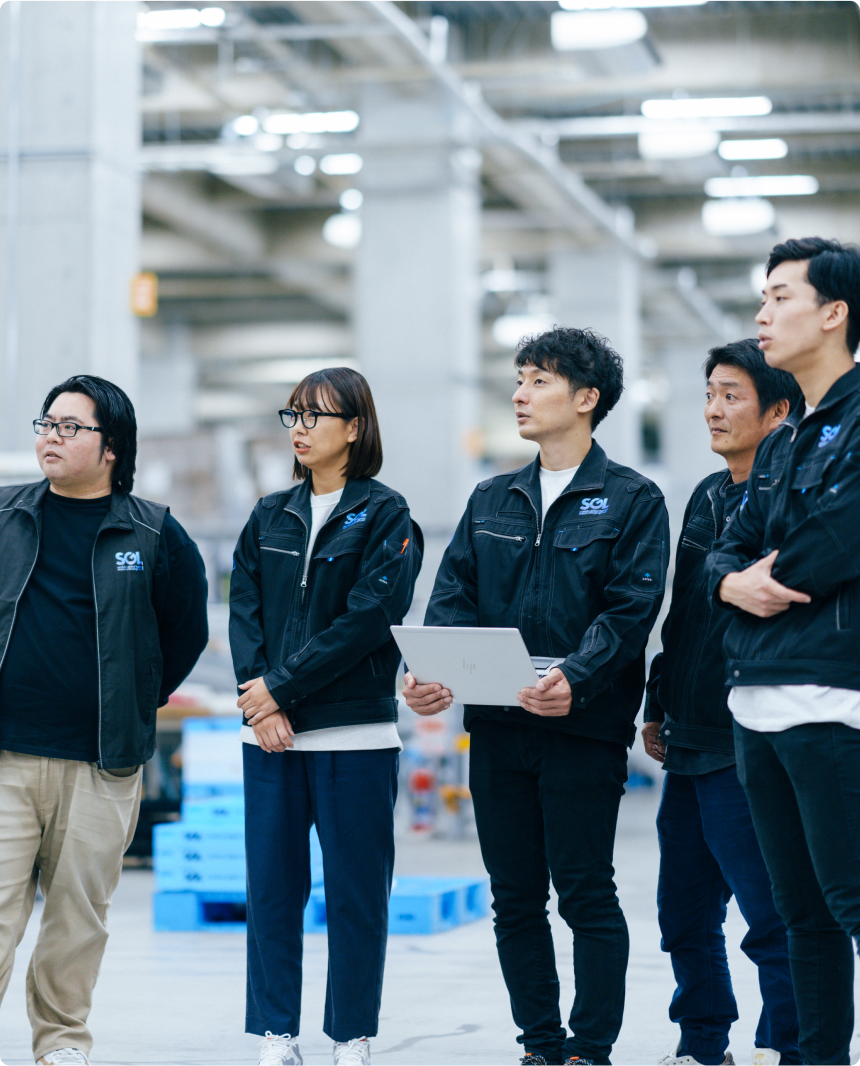 広い倉庫で研修を受ける5人のSGLスタッフ。